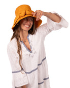 Model wearing Cara Saffron big bow embellishment handmade loomed raffia in a solid hue of saffron yellow/orange straw bucket style cloche sun hat with matching oversized bow - Shebobo