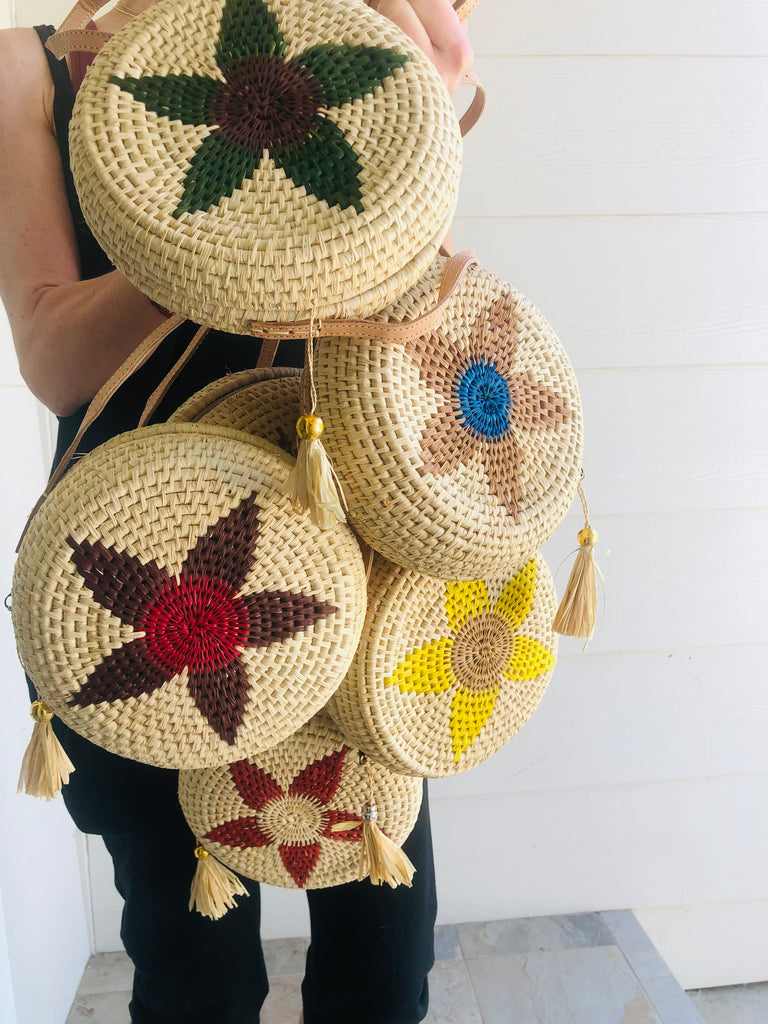 Model wearing multiple Carmel Crochet Round Flower Crossbody bag with Tassel Assorted Flower colors with adjustable leather strap and tassel zipper pull purse - sold assorted - Shebobo