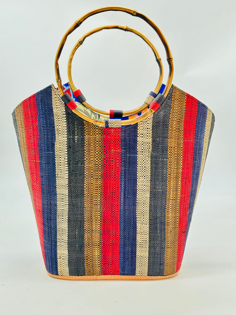 Carmen Solid/Stripes Straw Bucket Bag with Bamboo Handles Dark and Moody multicolor vertical stripe pattern of brown, red, blue, natural, and black with assorted liner purse - Shebobo
