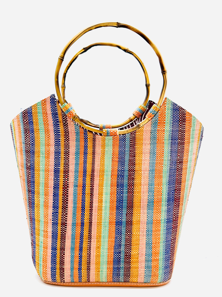 Carmen Solid/Stripes Straw Bucket Bag with Bamboo Handles Taffy multicolor vertical stripe pattern of blush, bordeaux, turquoise, orange, saffron, blue, and natural with assorted liner purse - Shebobo