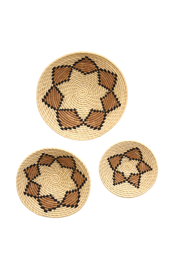 Raffia Straw Wall Decor Display Basket Tray: Set of 3 handmade woven natural raffia palm fiber in a crochet loop technique concentric coiled circular pattern with double natural straw color, cinnamon/tobacco/brown, and black centered star flower pattern set of three sized flat bowl trays - Shebobo