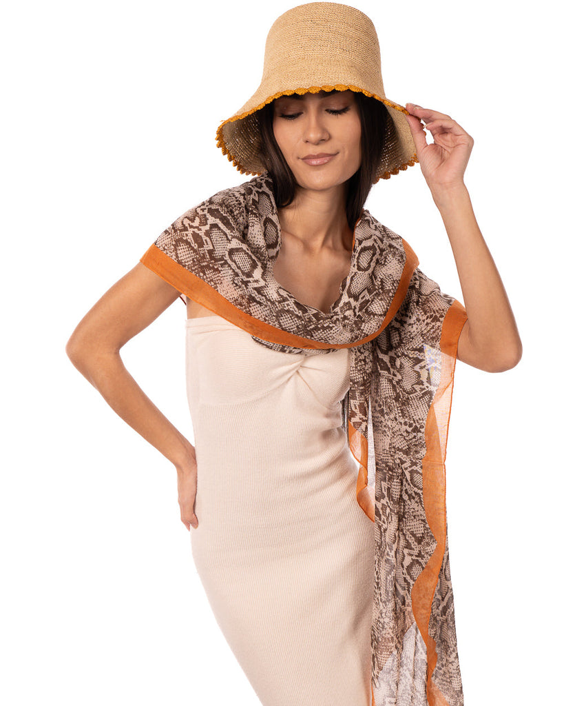 Model wearing Cleo Snake Print Scarf Wrap Coral Orange, Black, and White Multicolor Snake Skin Patterned Scarf with colored edge - Shebobo (with Kate 3" Brim Crochet Bucket Straw Sun Hats)