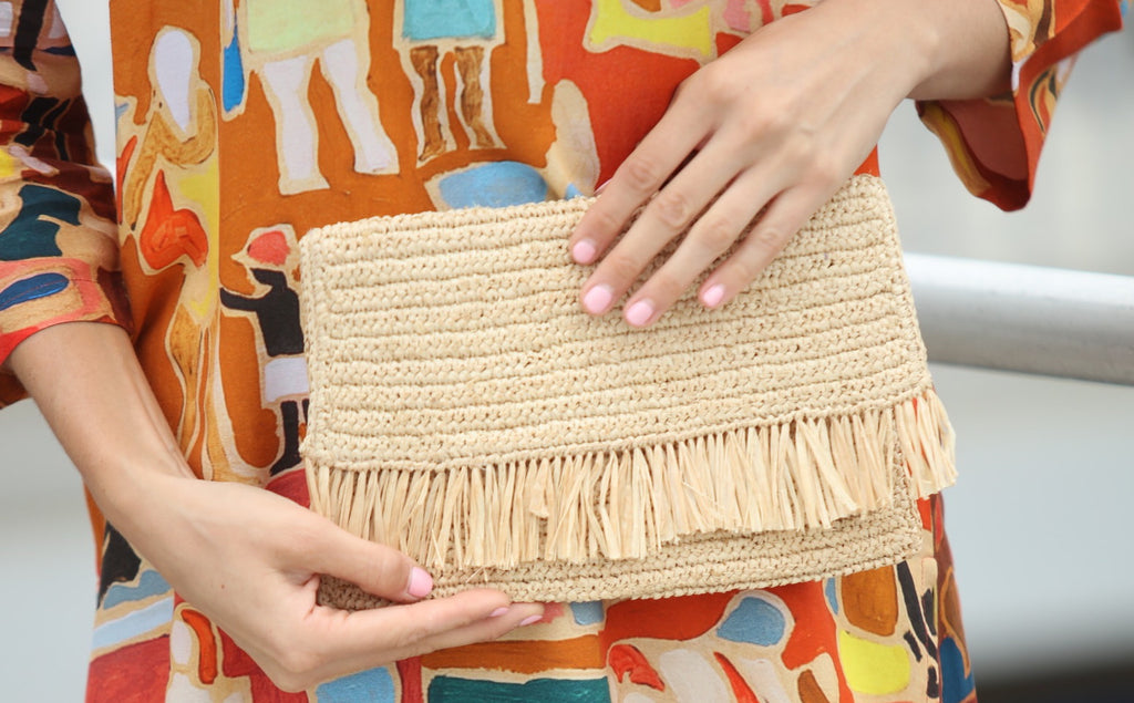 Model wearing Coco Fringe Crochet Straw Clutch natural straw color handmade purse with horizontal band of raw fringe - Shebobo