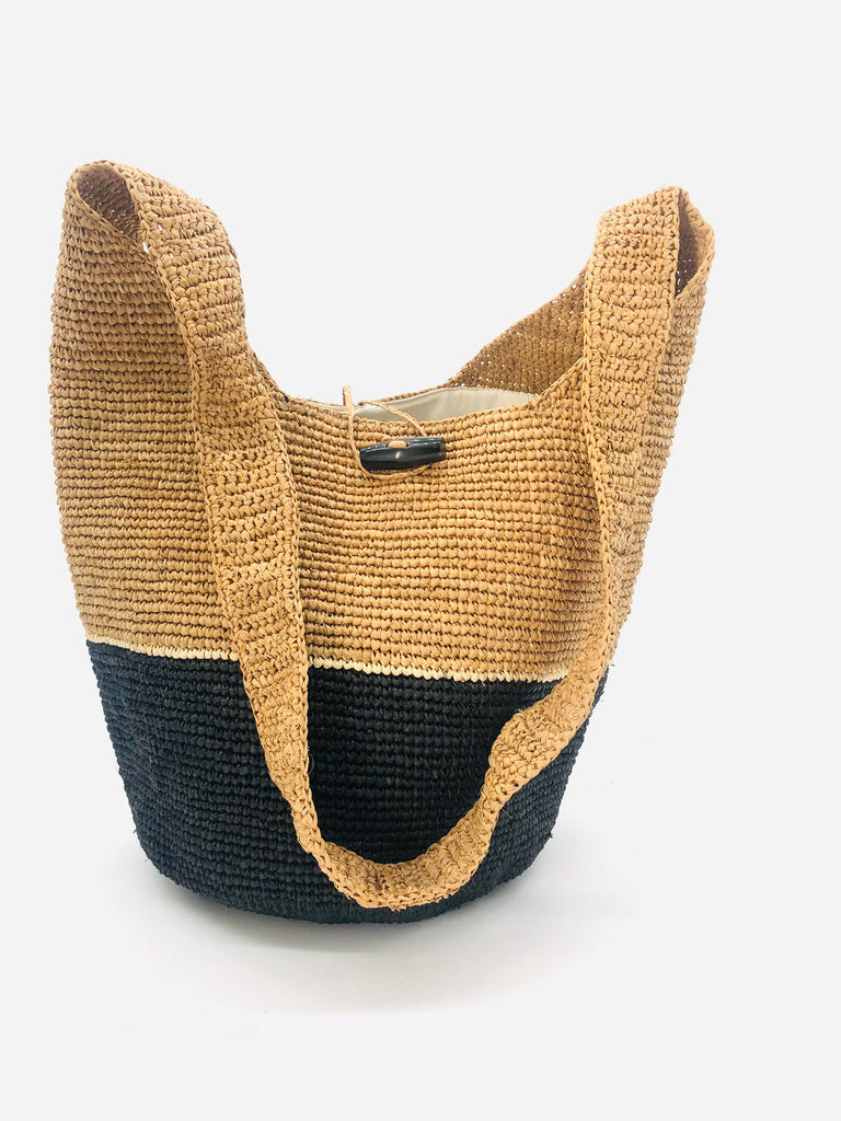 ConCon Two Tone Crochet Crossbody Bag handmade with interior liner, horn button and loop closure raffia purse black bottom, with narrow natural straw color horizontal stripe separating light brown/tea colored top & shoulder strap - Shebobo