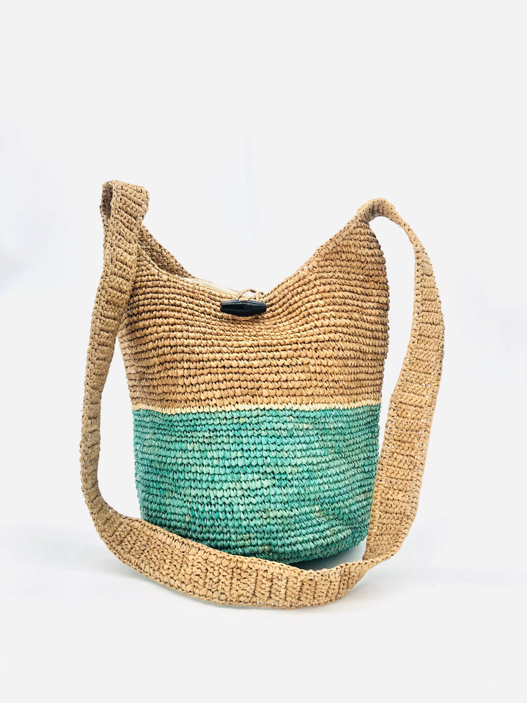 ConCon Two Tone Crochet Crossbody Bag handmade with interior liner, horn button and loop closure raffia purse seafoam/light turquoise greenish blue/teal bottom, with narrow natural straw color horizontal stripe separating light brown/tea colored top & shoulder strap - Shebobo