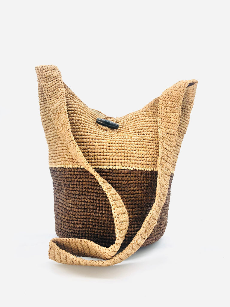 ConCon Two Tone Crochet Crossbody Bag handmade with interior liner, horn button and loop closure raffia purse cinnamon/tobacco/dark brown bottom, with narrow natural straw color horizontal stripe separating light brown/tea colored top & shoulder strap - Shebobo