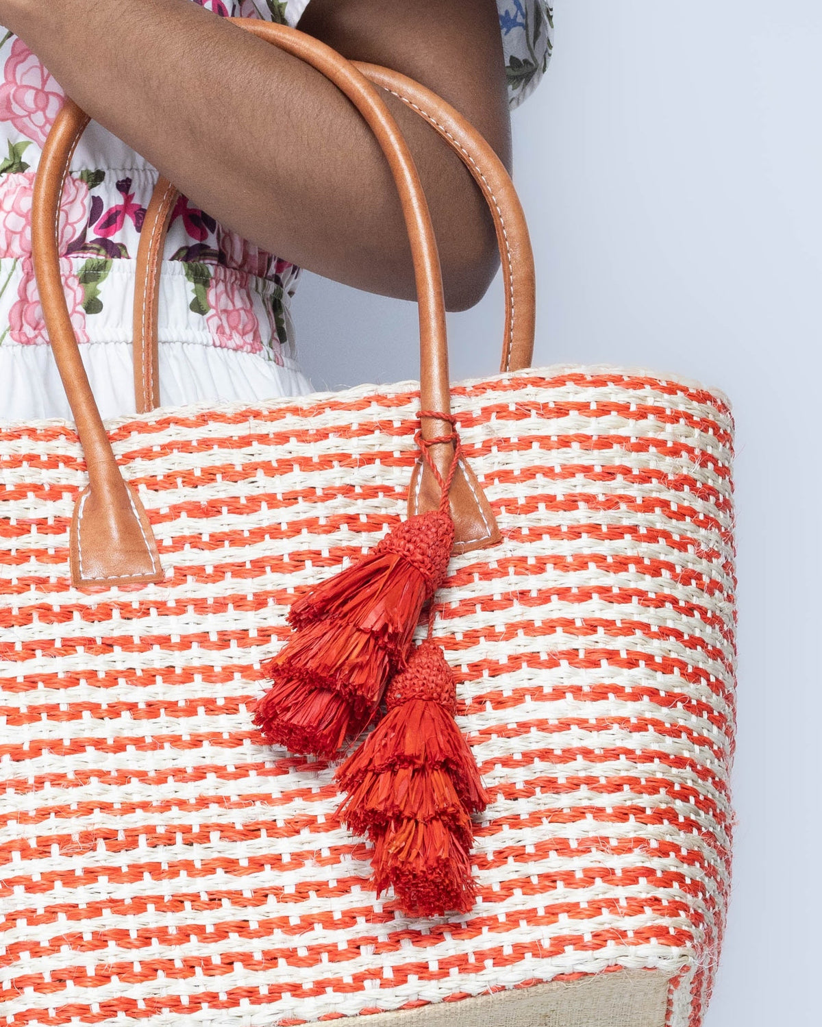 Model wearing Tassel Tie Two Layered Raffia Straw Tiered Tufts Charm Embellishment handmade crochet and brushed natural raffia palm fiber in a single hue layered tuft tassel of Coral orange/red beach bag handbag charm embellishment or party decor - Shebobo