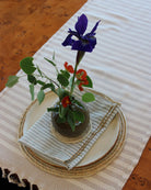 Lifestyle view Dabu Round Two Tone Swirl Raffia Straw Coasters & Placemats Set of 6 handmade natural raffia palm fiber in a crochet loop disc technique creating concentric circular stripe pattern of texture in a solid hue of natural straw color with matching knotted spiral swirl weave sets of six placemats or coasters - Shebobo