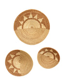Dakarai Raffia Straw Wall Decor Display Basket Trays: Set of 3 handmade woven raffia palm fiber in a crochet loop technique creating a concentric swirl pattern of bands of  cinnamon/tobacco/brown, cappuccino/tea/light brown, and natural straw color that create a two tone pattern with half of the disc being light brown, and the other half a sun burst pattern set of three sized flat bowl trays - Shebobo