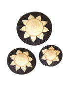 Dakarai Raffia Straw Wall Decor Display Basket Tray: Set of 3 handmade woven natural raffia palm fiber in a crochet loop technique concentric coiled circular pattern with centered natural straw color and brown circling ring and natural sunburst floral design pattern up the otherwise black sides of the disc set of three sized flat bowl trays - Shebobo