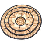 Detail view Dakarai Raffia Straw Wall Decor Display Basket Tray: Set of 3 handmade woven natural raffia palm fiber in a crochet loop technique concentric coiled circular pattern with natural straw color, cappuccino/tea/light/brown, cinnamon/tobacco/dark/brown, and black centered star flower pattern set of three sized flat bowl trays - Shebobo