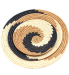 Detail view Dakarai Raffia Straw Wall Decor Display Basket Trays: Set of 3 handmade woven raffia palm fiber in a crochet loop technique creating a concentric swirl pattern of bands of natural straw color, cinnamon/tobacco/brown, and black in a three tone spiral from the center to the outer edge set of three sized flat bowl trays - Shebobo
