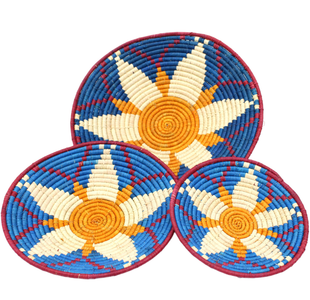 Dakarai Raffia Straw Wall Decor Display Basket Tray: Set of 3 handmade woven natural raffia palm fiber in a crochet loop technique concentric coiled circular pattern with natural straw color, saffron orange/yellow, blue, and red centered star flower pattern set of three sized flat bowl trays - Shebobo