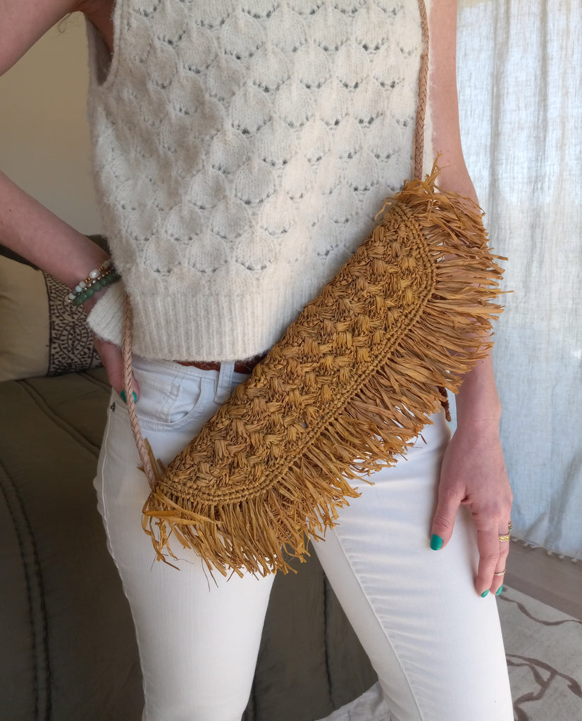 Model wearing Elsea handmade crochet cinnamon/tobacco/brown raffia palm crossbody bag with brushed fringe raw edge and macrame knot fabric lined purse with woven leather shoulder strap - Shebobo