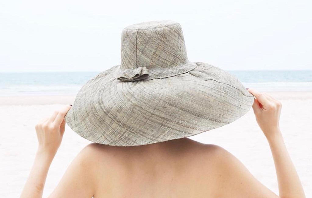 Model wearing Estrella 7 inch wide brim floppy sun hat handmade loomed raffia grey packable womens straw hat - Shebobo