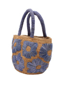 Side view Eva Embroidered Flower Crochet Straw Basket Handbag two tone handmade crochet raffia palm in a solid hue of cappuccino tea/light/brown with denim light/retro/blue straw color embroidered floral pattern and matching denim crochet handles beach bag tote purse - Shebobo