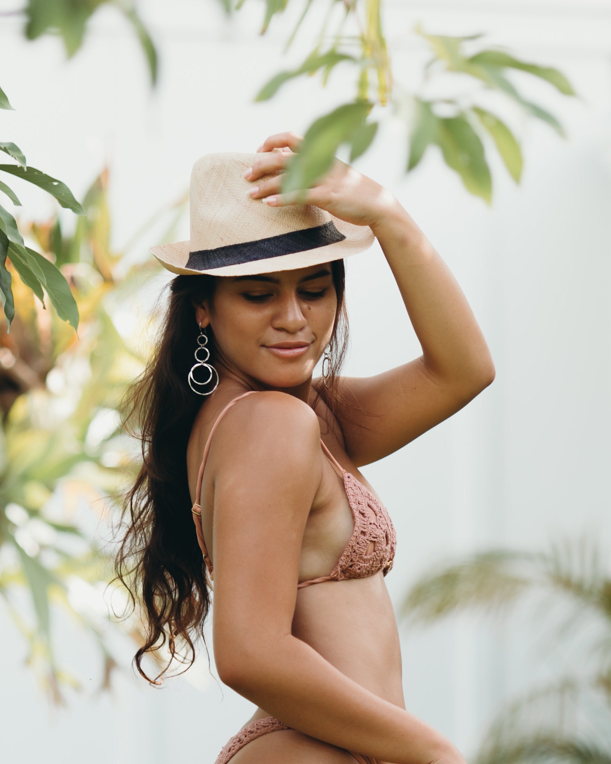 Model wearing Fedra Natural with Black Hat Band - Unisex Fedora Straw Hat handmade loomed natural raffia palm fiber in a solid hue of natural straw color with an attached black hat band - Shebobo