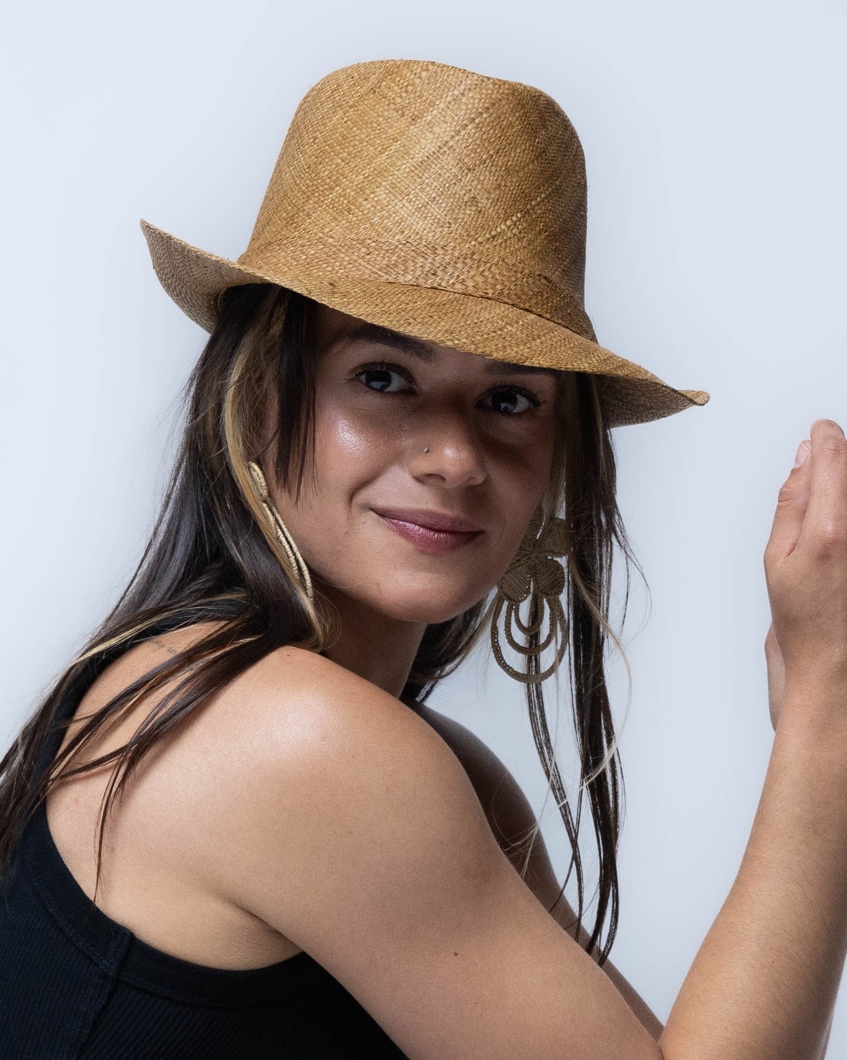 Model wearing Fedra 2" Brim Fedora Unisex Straw Hats Tobacco handmade loomed natural raffia palm fiber in a solid hue of tobacco cinnamon/dark/brown with an attached matching hat band - Shebobo