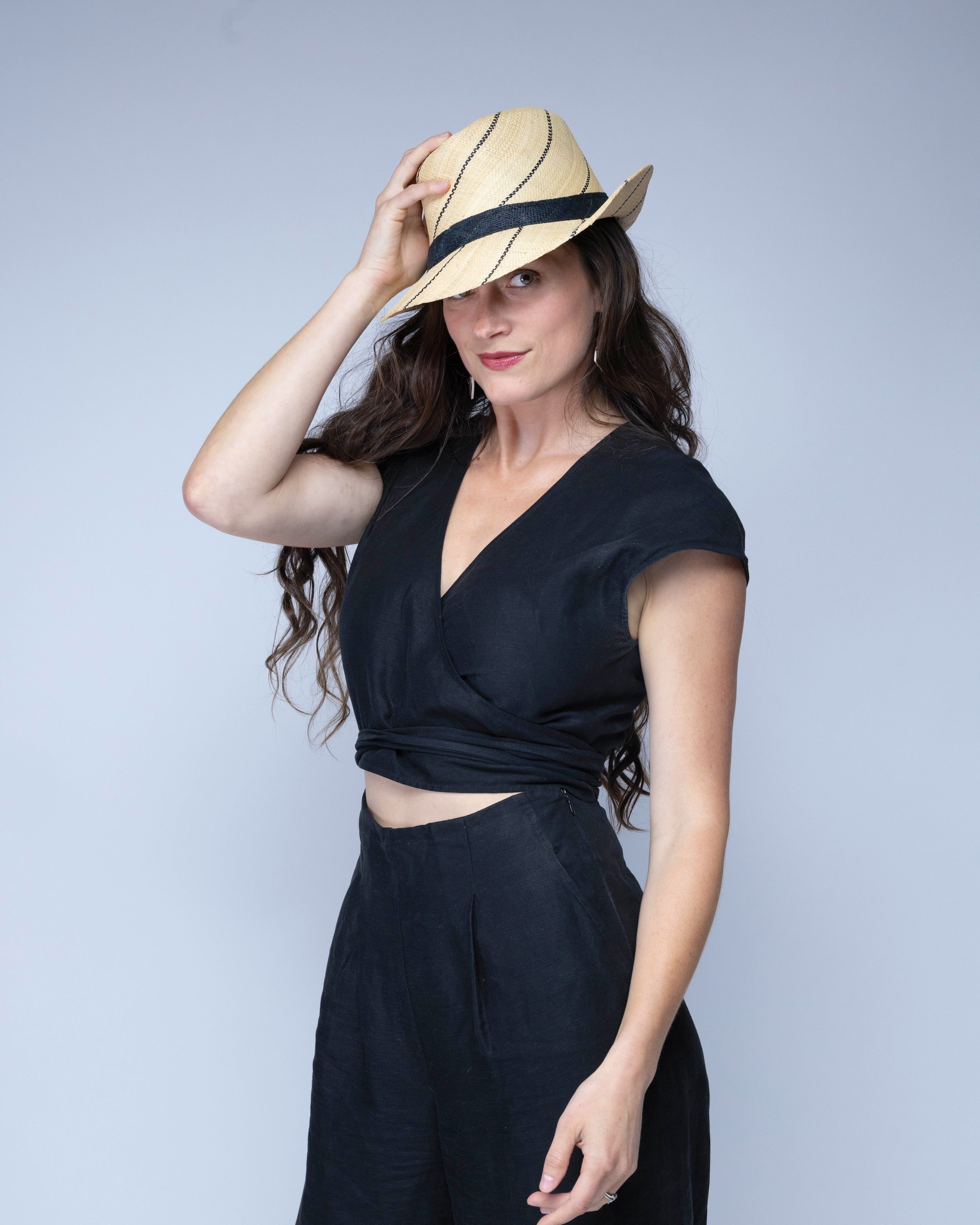 Model wearing Model wearing Fedra 2" Brim Fedora Unisex Straw Hats natural and black pinstripes packable raffia straw hat handmade loomed raffia in wide bands of natural straw color with black narrow bands create a stripe swirl pattern - Shebobo