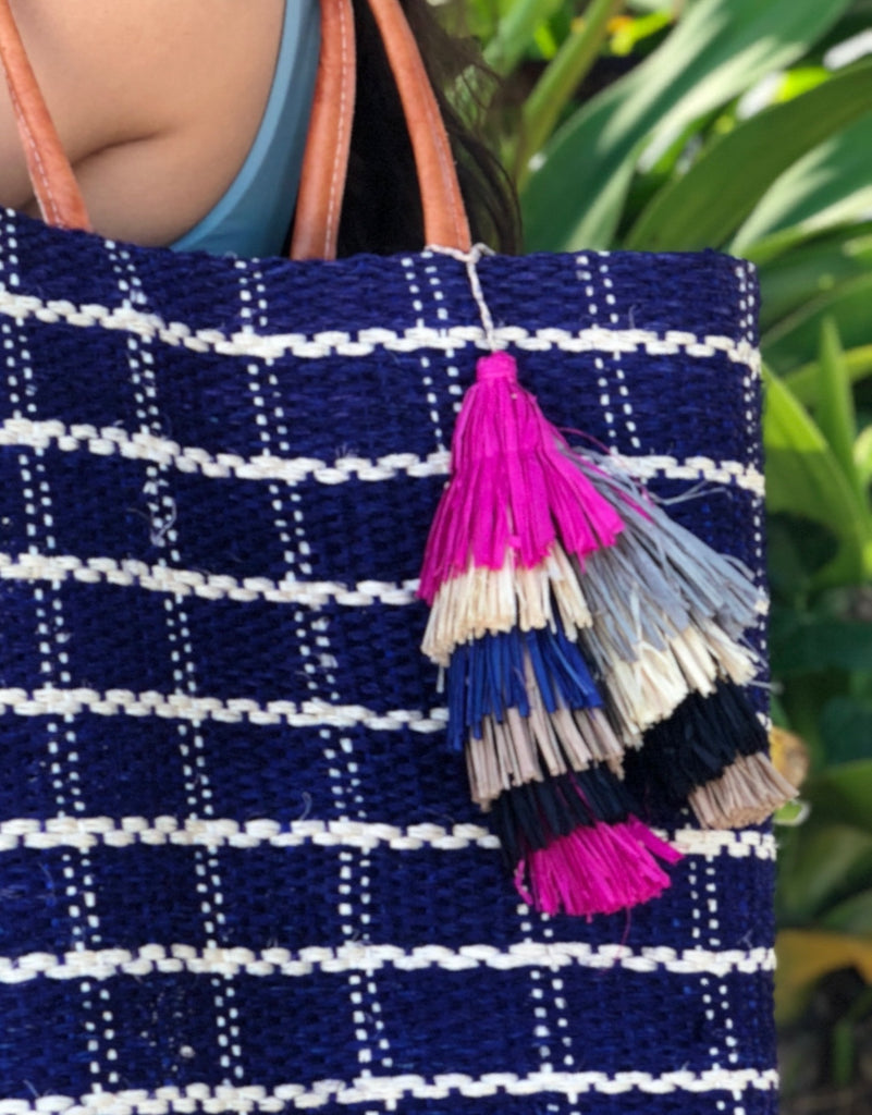 Model wearing Tassels Layered Raffia Tufts Charm Embellishment Fiesta Multicolor handmade knotted and brushed natural raffia palm fiber in a multicolor layered tuft tassel of fuchsia hot/bright/barbie/pink, natural straw color, grey, dark blue, black, and cappuccino light/brown beach bag handbag charm embellishment or party decor - Shebobo