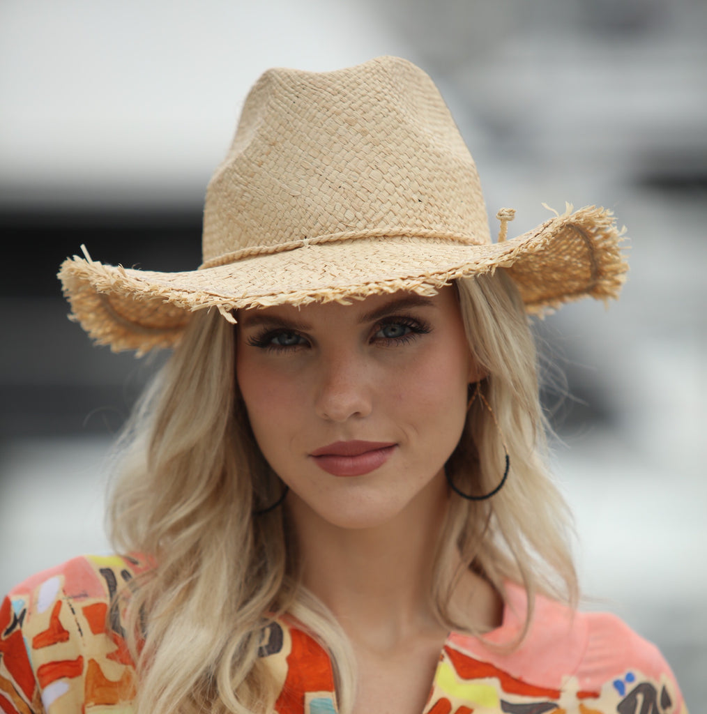 Model wearing Fiston Fringe Natural - Unisex Fedora Straw Hat with Raw Edge handmade woven raffia strands in a solid hue of natural straw color with matching raw fringe edge embellishment and twisted raffia cord hat band - Shebobo