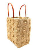 Side View Flower Power Natural Crochet Straw Basket Bag handmade from natural raffia palm fiber in a granny square geometric floral pattern with petite flower detailing per square, crochet textile in a natural straw color with leather handles handbag purse - Shebobo