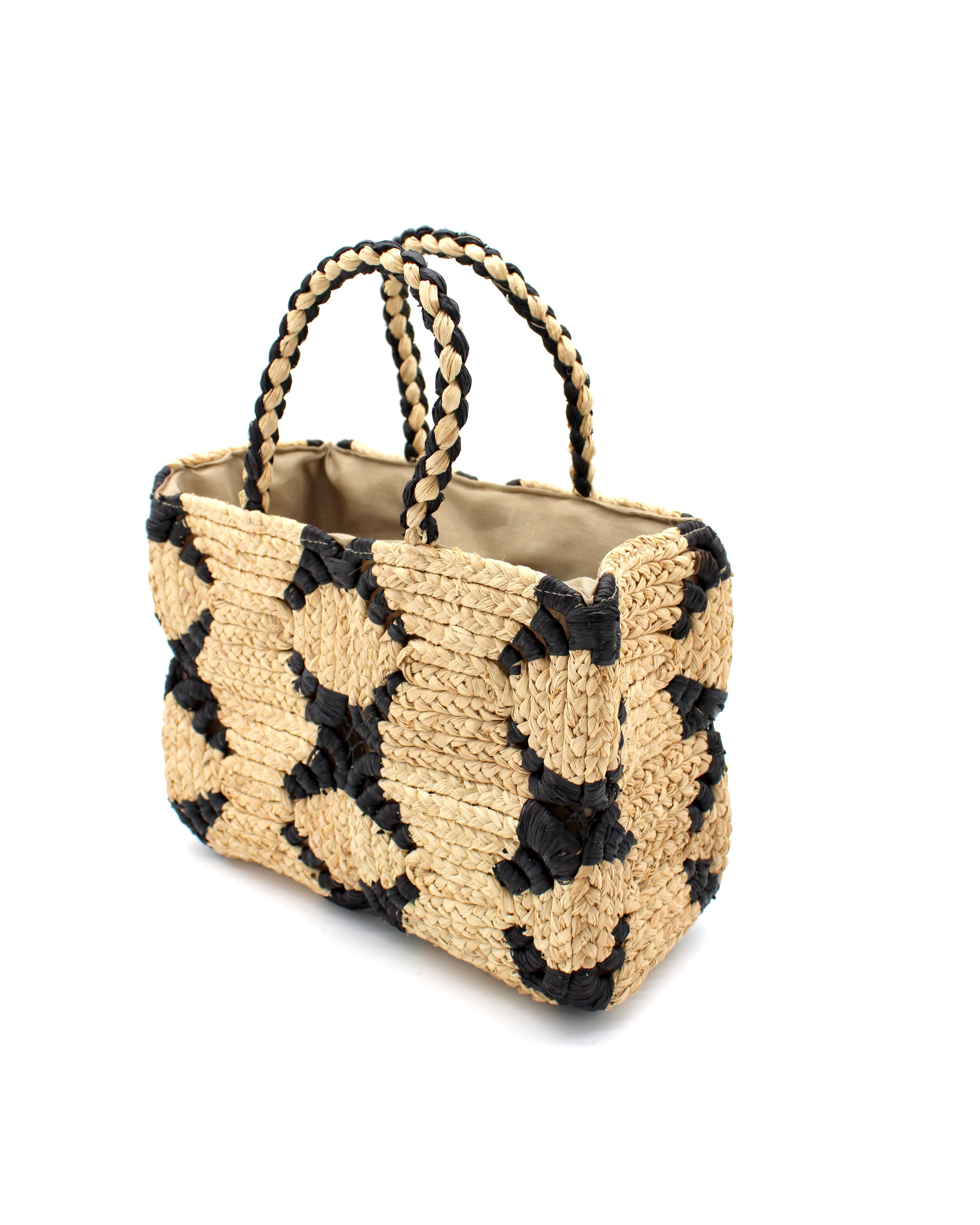 Side View Gemma Crochet Disc Rectangle Black and Natural Straw Basket Handbag handmade woven raffia palm fiber in a two tone multicolor pattern of black and natural straw color create a coiled braid disc pattern result in a star pattern around the bag with matching woven handles top handle bag - Shebobo