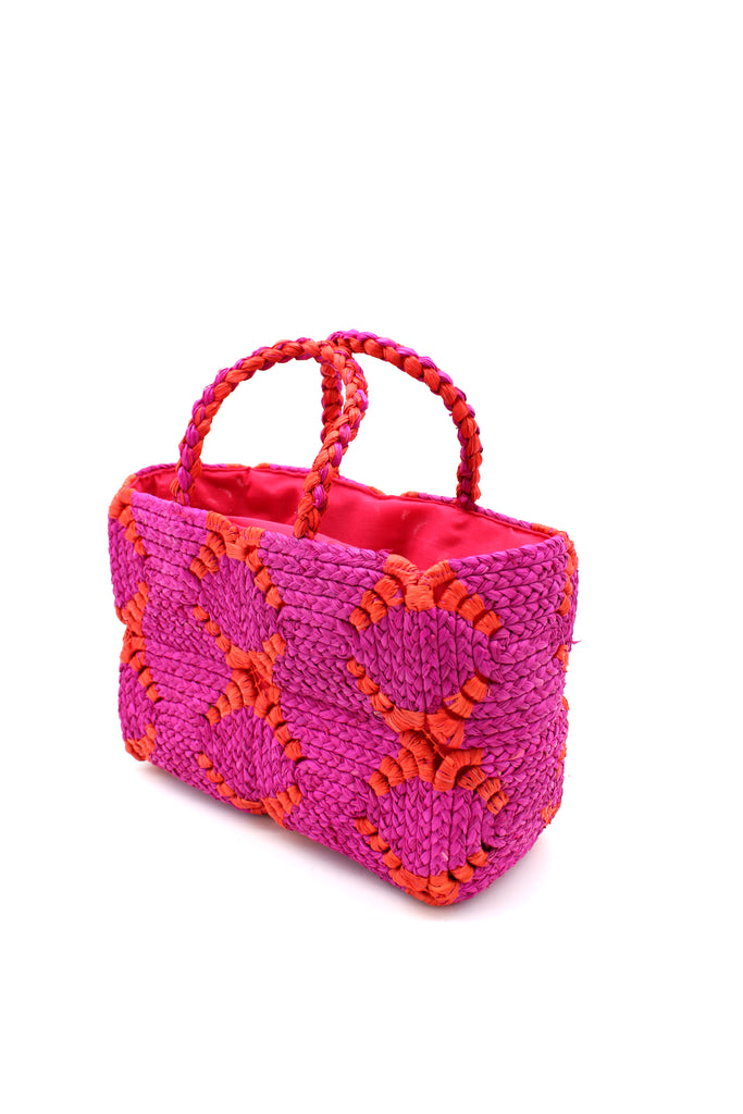 Side View Gemma Crochet Disc Rectangle Fuchsia and Coral Straw Basket Handbag handmade woven raffia palm fiber in a two tone multicolor pattern of fuchsia hot/bright/barbie/pink and coral red/orange create a coiled braid disc pattern result in a star pattern around the bag with matching woven handles top handle bag - Shebobo