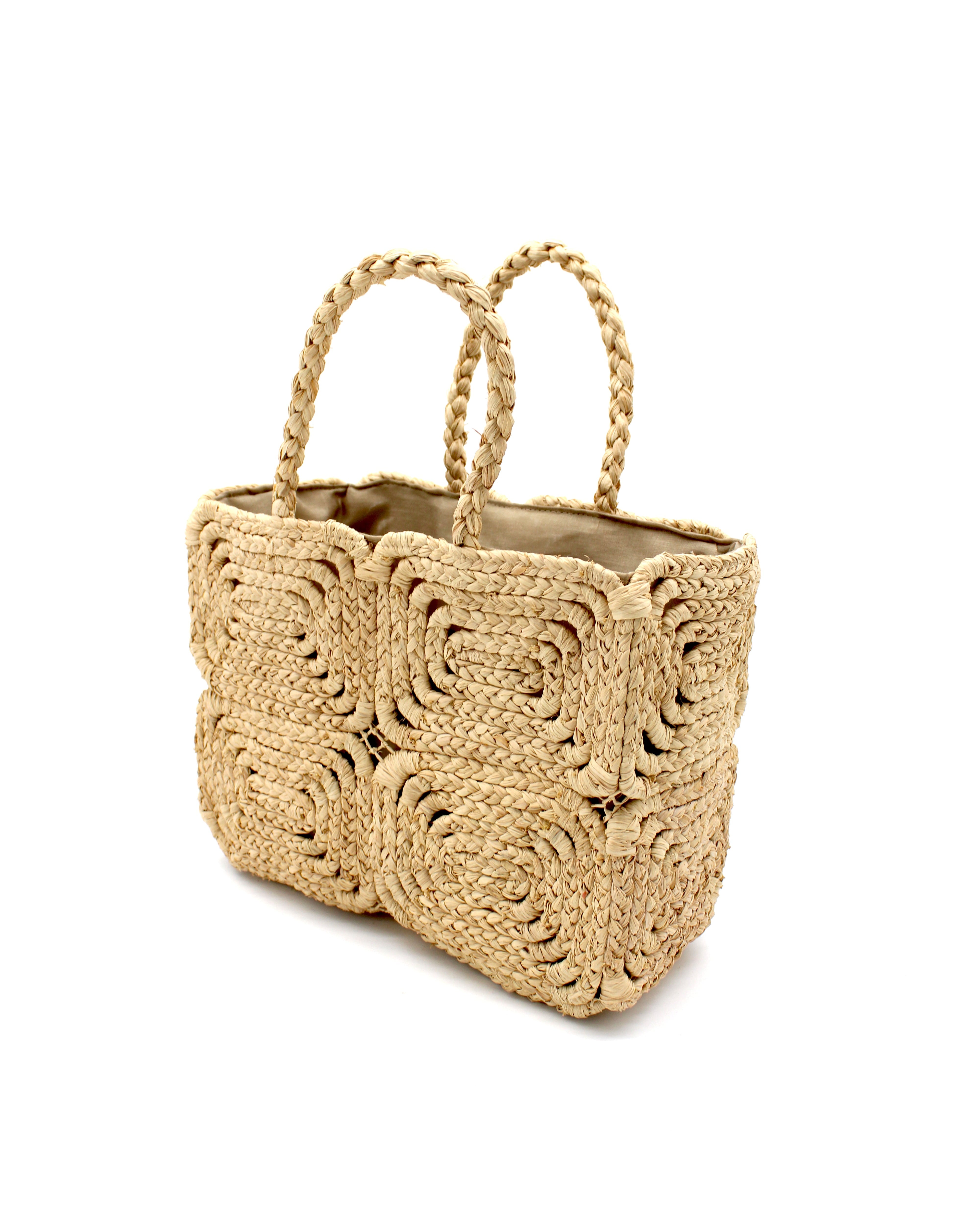 Side View Gemma Crochet Disc Rectangle Natural Straw Basket Handbag handmade woven raffia palm fiber in a solid hued pattern of natural straw color create a coiled braid disc pattern result in a star pattern around the bag with matching woven handles top handle bag - Shebobo