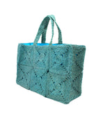 Side view Gemma Crochet Disc Rectangle Large Straw Basket Handbag handmade braided natural raffia palm fiber in a solid hue of turquoise blue/green with subtle square disc pattern around the outside of the bag in two horizontal bands of squares creating a geometric pattern and matching woven handles beach bag purse - Shebobo