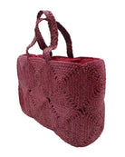 Side view Gemma Crochet Disc Rectangle Large Straw Basket Handbag handmade braided natural raffia palm fiber in a solid hue of Umberwine burgundy/bordeaux/dark/purple/red with subtle square disc pattern around the outside of the bag in two horizontal bands of squares creating a geometric pattern and matching woven handles beach bag purse - Shebobo