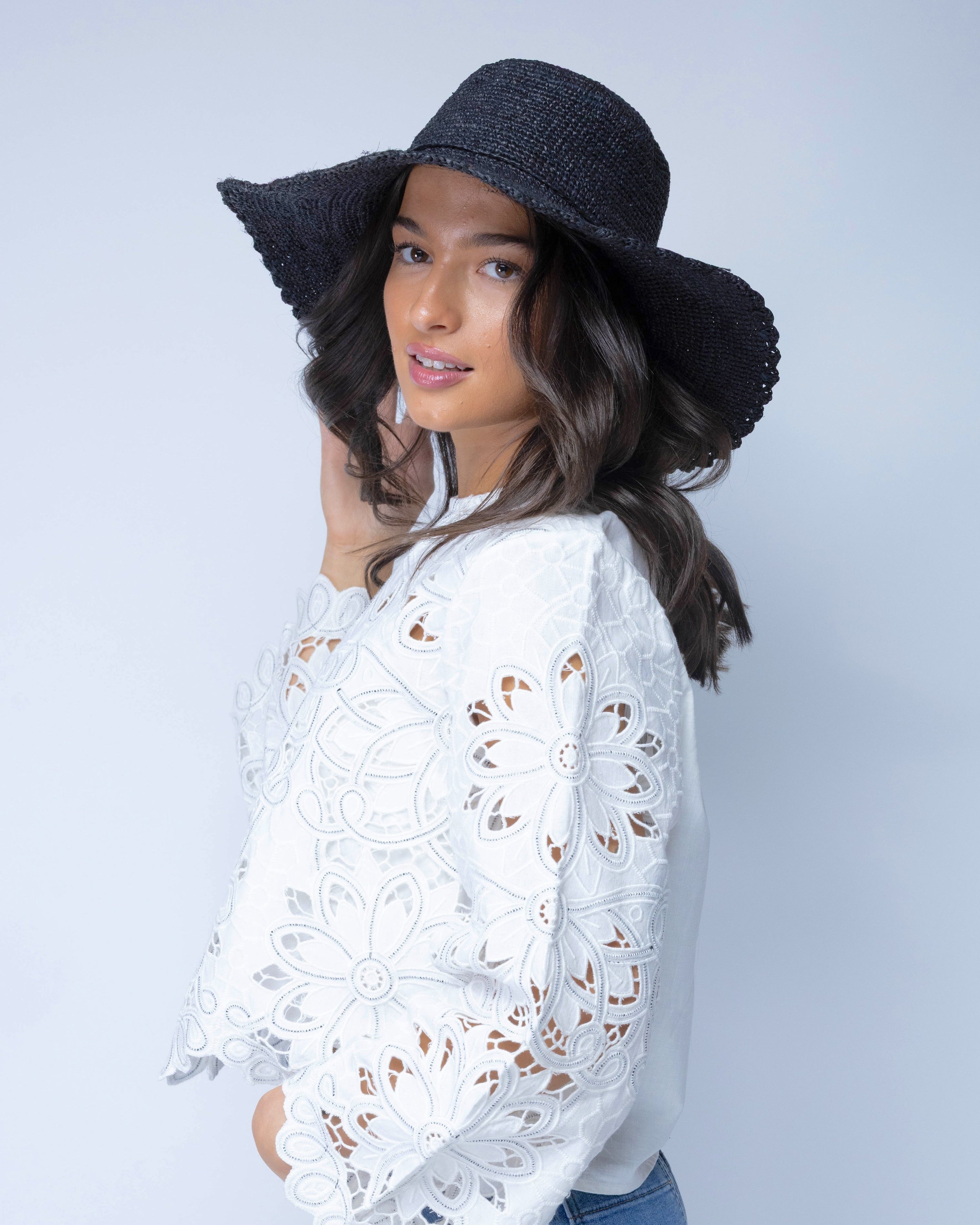 Model wearing 4" Brim Genevieve Black Crochet Straw Sun Hat with Lace Weave Edge handmade raffia palm fiber crochet solid hue black rounded crown with detailed lace weave edge and matching adjustable hat band - Shebobo