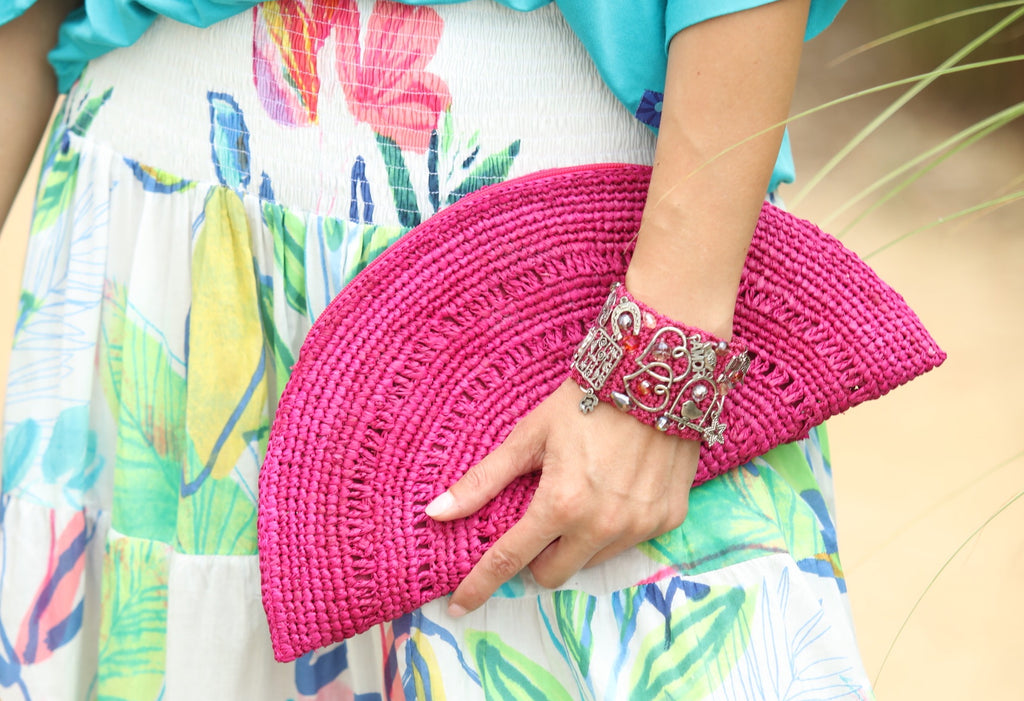 Model wearing Half Moon XL Fuchsia Crochet Straw Clutch with Tassel Zipper Pull handmade with weave creating varying half circle bands of texture - Shebobo