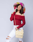 Model wearing Hana Mini ConCon Crochet Petite Raffia Straw Basket Handbag Convertible Crossbody Bag with Fringe Purse handmade raffia palm fiber in a solid hue of natural straw color in a subtle band crochet link texture with horizontal multi tired layers of fringe around the center third of the bag with matching detachable crossbody strap - Shebobo