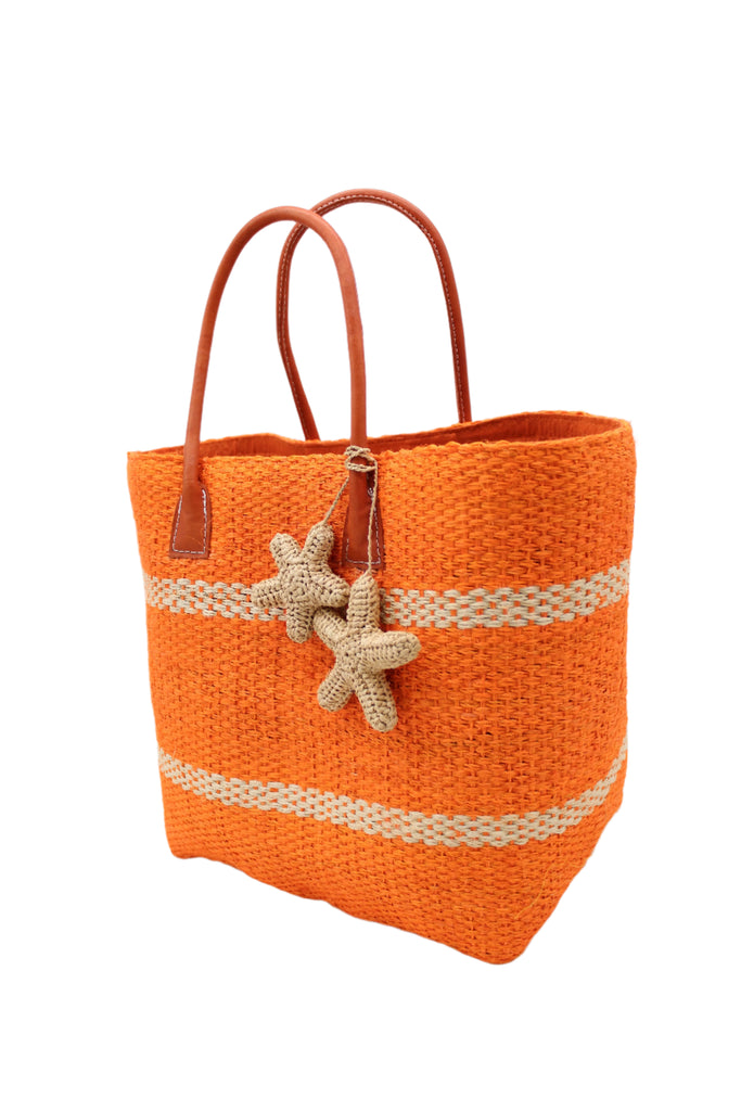 Side view Havana Sisal Basket Bag with Tassel Charm Embellishment handmade sisal fiber woven into horizontal wide bands of coral orange with two evenly spaced narrow bands of natural straw color create a stripe pattern with natural crochet starfish charm embellishment and leather handles handbag shoulder bag - Shebobo