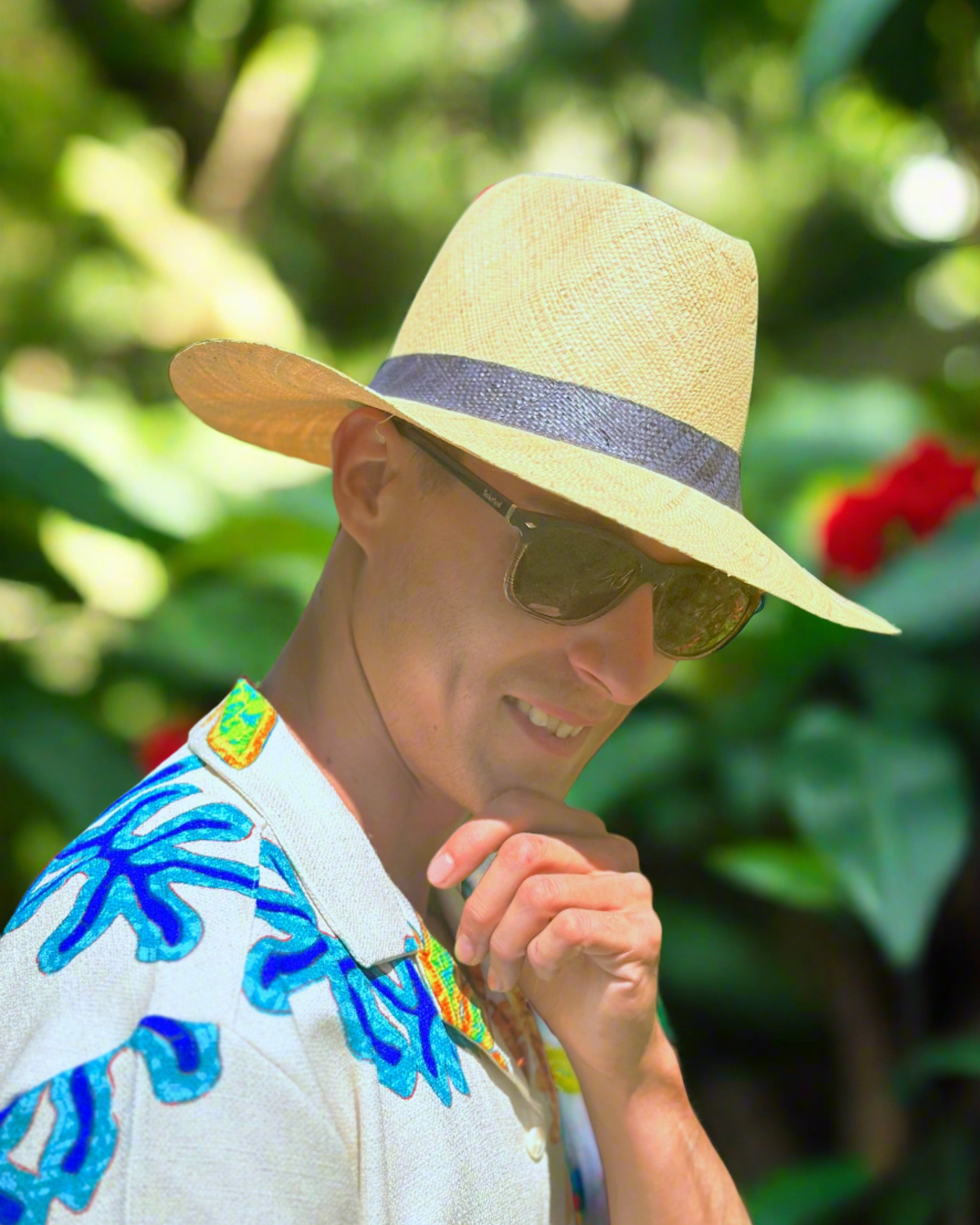 Model wearing Jamie Panama 3" brim handmade loomed raffia unisex straw sun hat in natural straw color with loomed black band - Shebobo