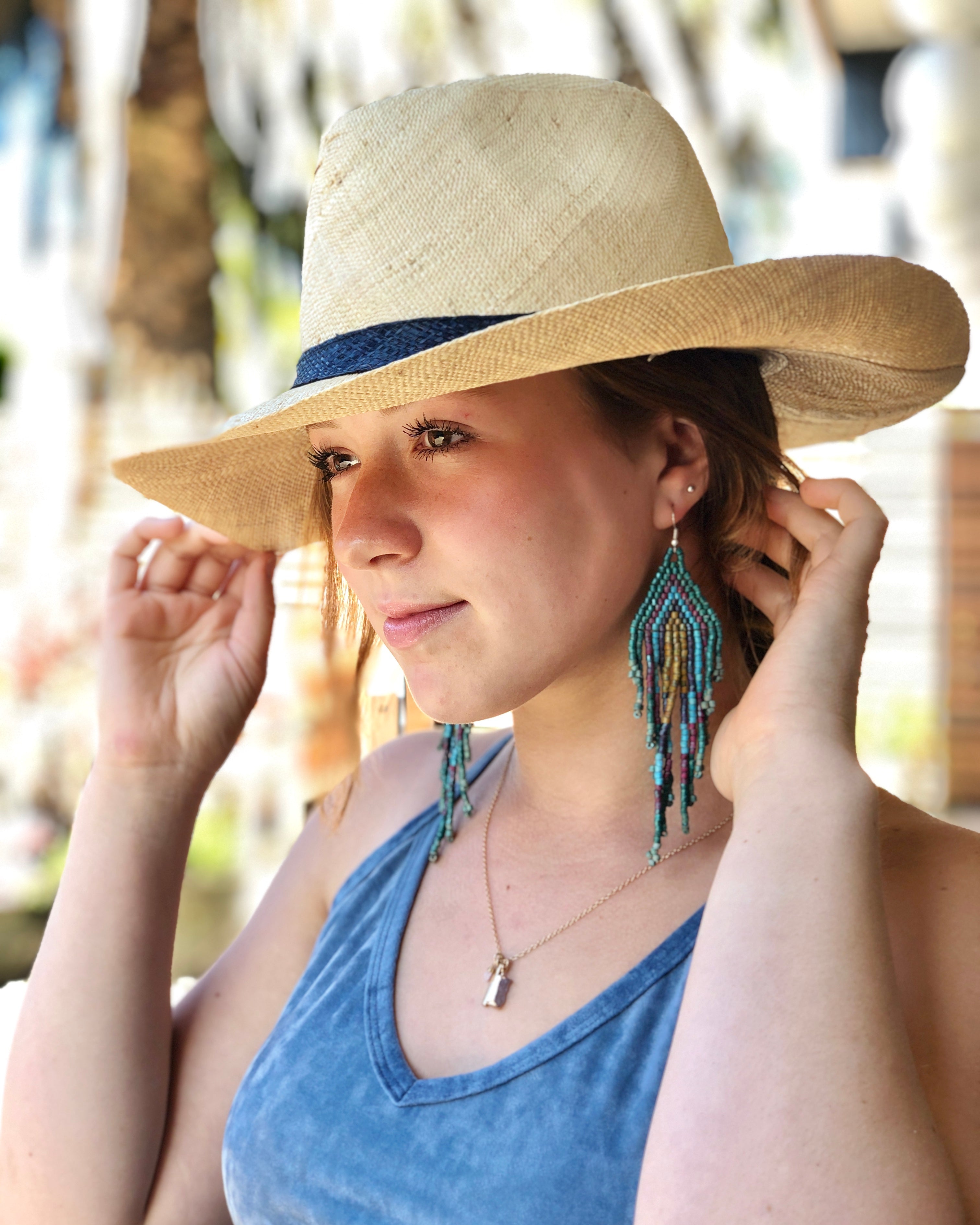 Model wearing Jamie Panama 3" brim handmade loomed raffia unisex straw sun hat in natural straw color with loomed black band - Shebobo