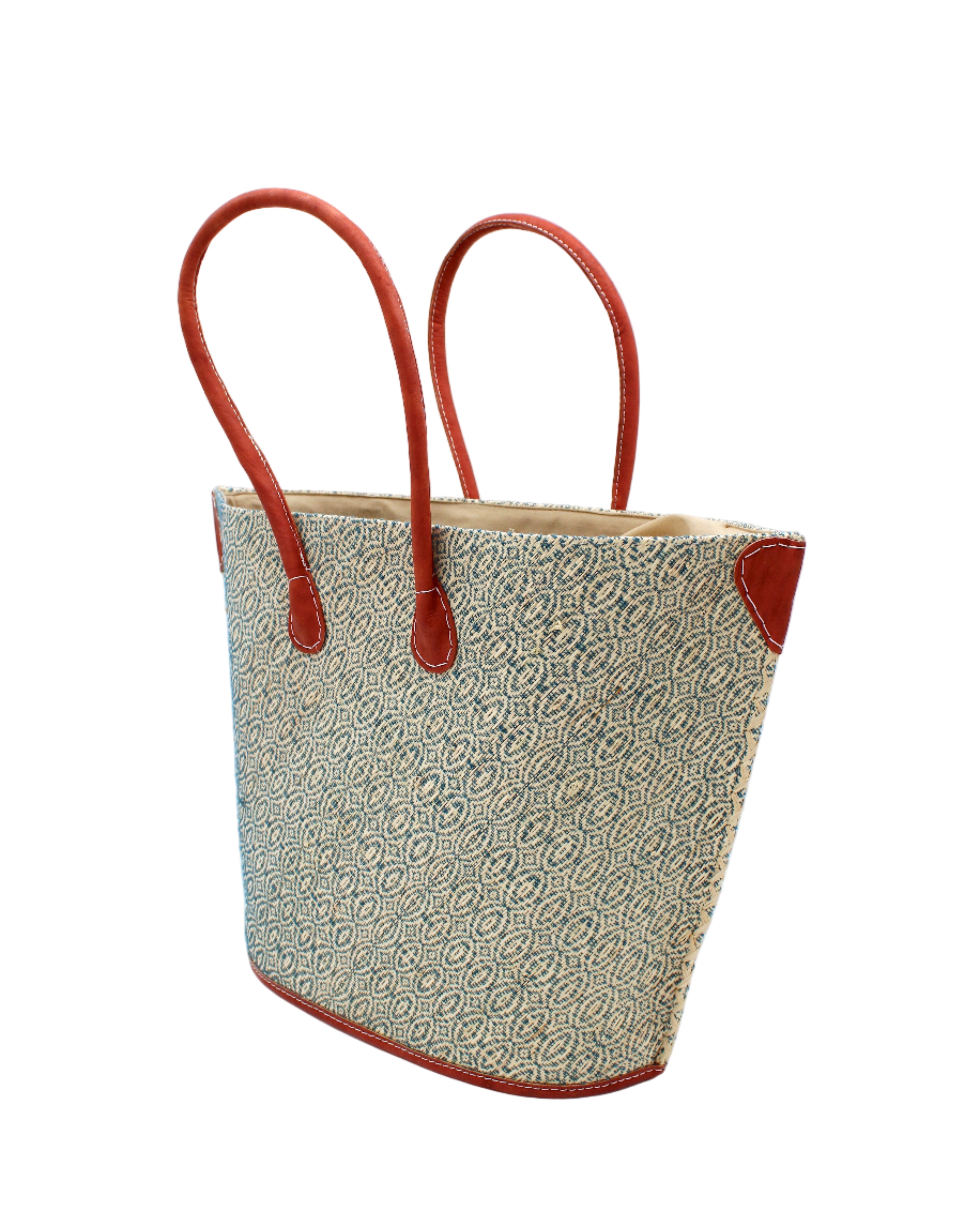 Side view Josephine Woven Small Straw Tote Bag handmade natural raffia palm fiber in natural straw color woven with contrasting Turquoise blue/green thread stitching in a subtle diagonal stripe pattern consisting of bands of ovals and circles with natural cross-stitch edge and leather handles beach bag shoulder bag - Shebobo