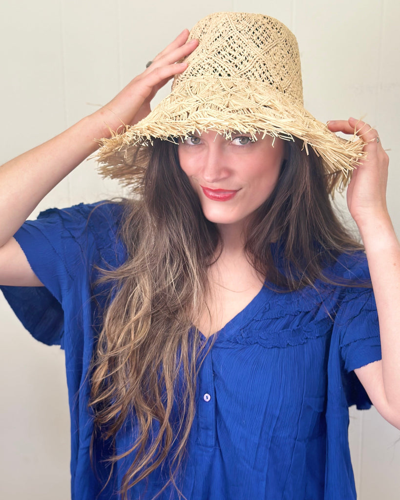 Model wearing Karin Crochet & Macrame Natural Raffia Knotted Straw Sun Hat Lightweight Breathable with Fringe Edge geometric star or sunburst design brim and geometric knotted diamond pattern top - Shebobo