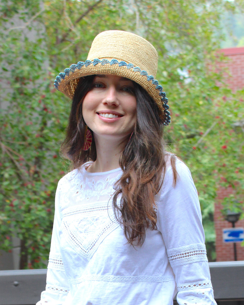Model wearing Kate Natural with Denim Crochet Bucket Straw Hats with Colored Lace Weave Edge handmade woven raffia palm fiber in a solid hue of natural straw color in a subtle link texture with denim retro/light/blue lace weave floral edge trim around the outer brim two tone multicolor uv protection hat - Shebobo