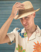 Model wearing Kelly Crochet Fedora - Unisex Straw Sun Hats handmade woven natural raffia palm fiber in a solid hue of natural straw color with woven in hatband of  cinnamon/tobacco/brown - Shebobo