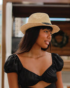 Model wearing Kelly Crochet Fedora - Unisex Straw Sun Hats handmade woven natural raffia palm fiber in a solid hue of natural straw color with woven in hatband of  black - Shebobo
