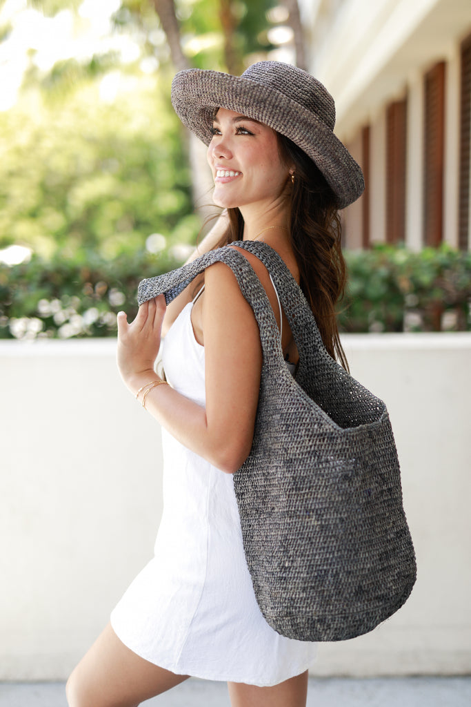 Model wearing Kiki Crochet Straw Crossbody Bag handmade oversized beach bag purse in woven grey raffia fibers - Shebobo (with Leor Grey Crochet Straw Hat)