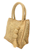 Side view of Kimba Crochet Handbag with Sphere Tassel Charm Embellishment handmade natural raffia palm fibers crochet into a granny square pattern with cappuccino/light brown detail edging - Shebobo