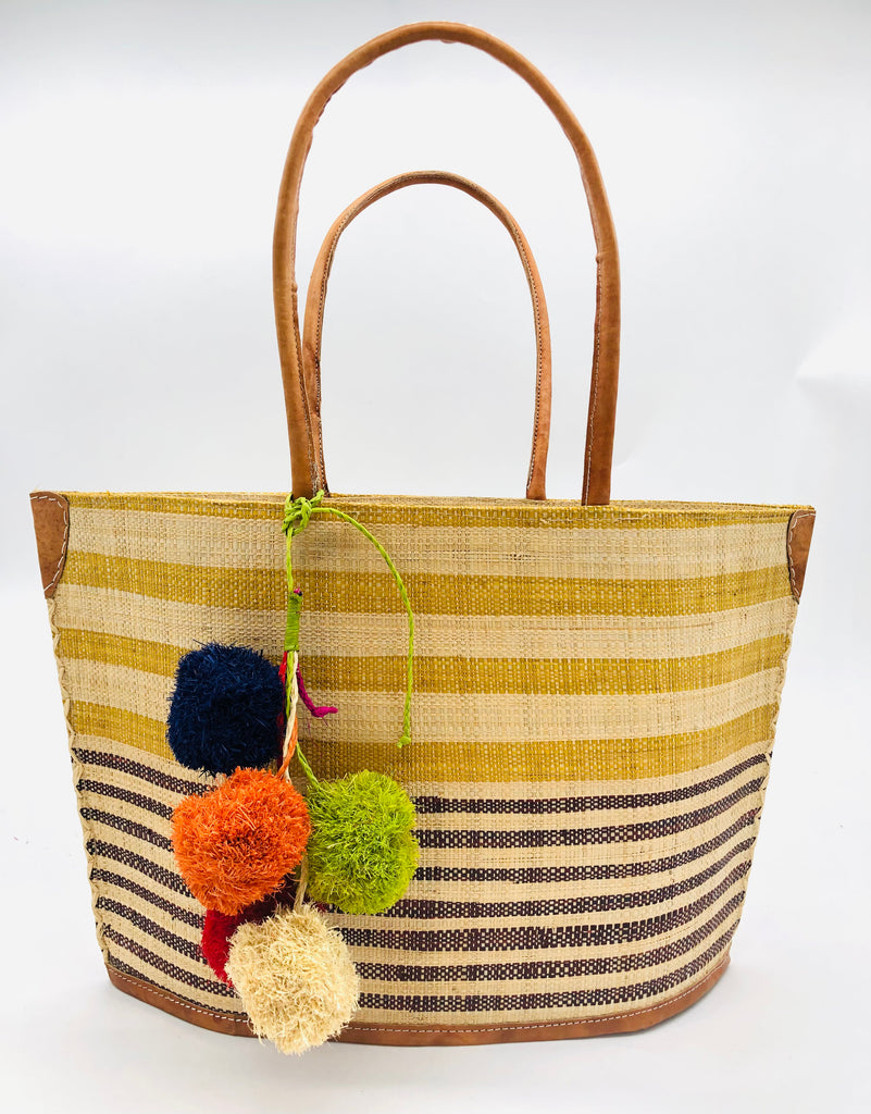 Laguna handmade loomed raffia handbag straw tote bag cinnamon/tobacco/light brown and natural horizontal stripes of medium width on the top half, and black/chocolate/dark brown and natural narrow width horizontal stripes on the lower half plus leather handles, and a multicolor fuschia pink, navy blue, lime green, orange, natural, and red pompom cluster charm embellishment - Shebobo