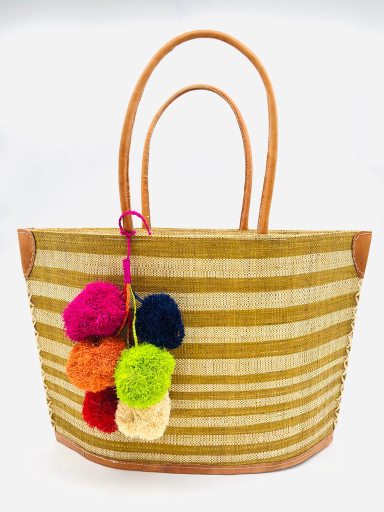 Laguna handmade loomed raffia handbag straw tote bag cinnamon/tobacco/light brown and natural horizontal stripes of medium width on the top half, and narrow width horizontal stripes on the lower half plus leather handles, and a multicolor fuschia pink, navy blue, lime green, orange, natural, and red pompom cluster charm embellishment - Shebobo