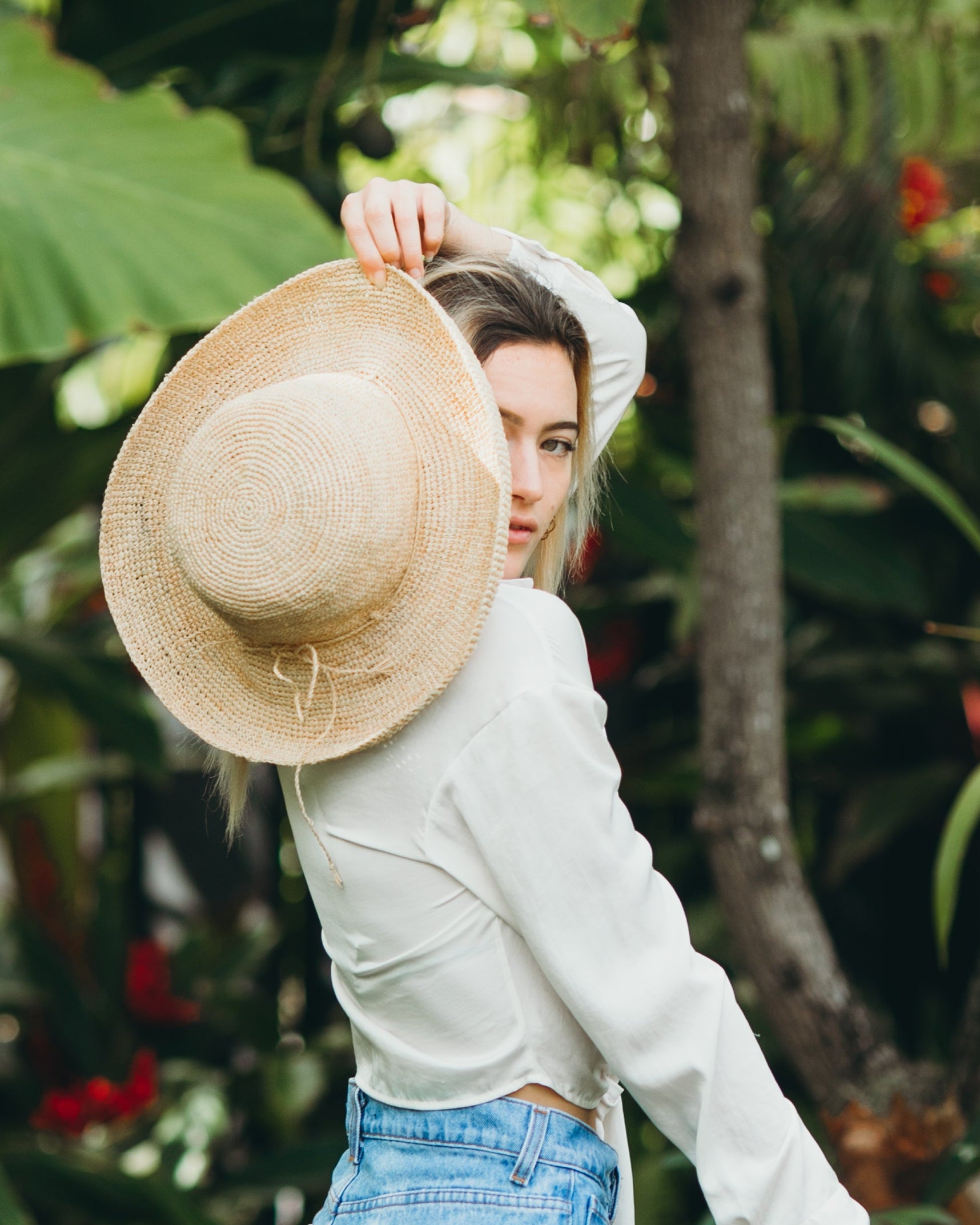 Model wearing Leor crochet straw hat handmade natural straw color raffia 3" brim packable straw hat - Shebobo