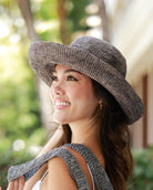 Model wearing 3" Brim Leor grey handmade crochet packable straw hat with adjustable band - Shebobo