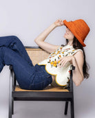 Model wearing Leor Sunkist crochet straw hat handmade woven natural raffia palm fiber in a solid hue of Sunkist ora raffia 3" brim packable straw hat with matching adjustable braided hat band - Shebobo