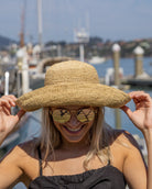 Model wearing Leor Natural crochet straw hat handmade natural straw color raffia 3" brim packable straw hat with matching adjustable braided hat band - Shebobo